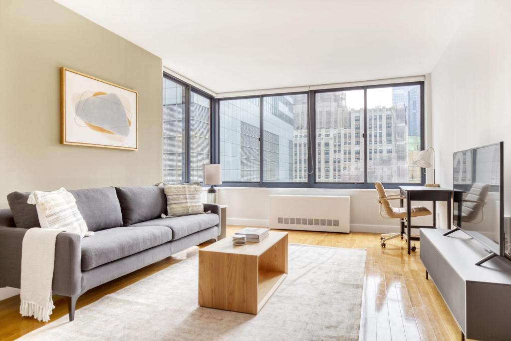 ニューヨークにあるMidtown 1BR w DM Elevator Gym nr Times Sq NYC-798のソファとテーブルのあるリビングルーム