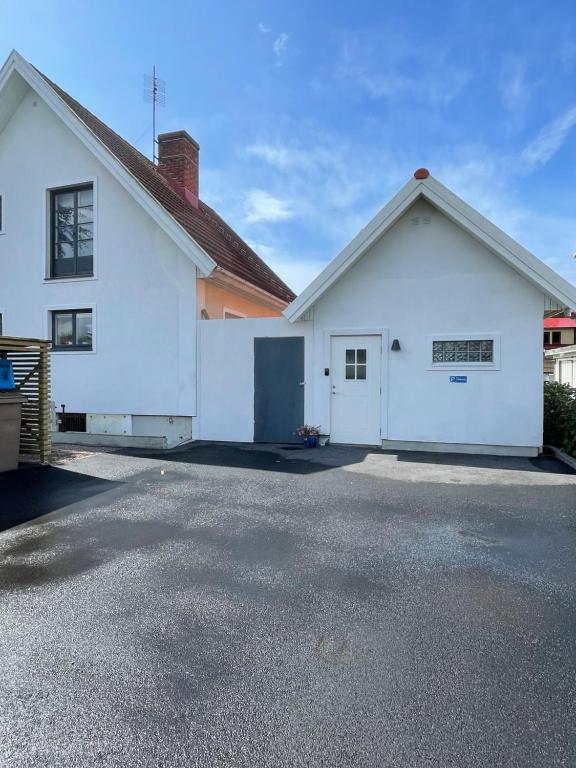 uma casa branca com uma garagem e uma entrada em Kaptenhuset Skrea strand em Falkenberg