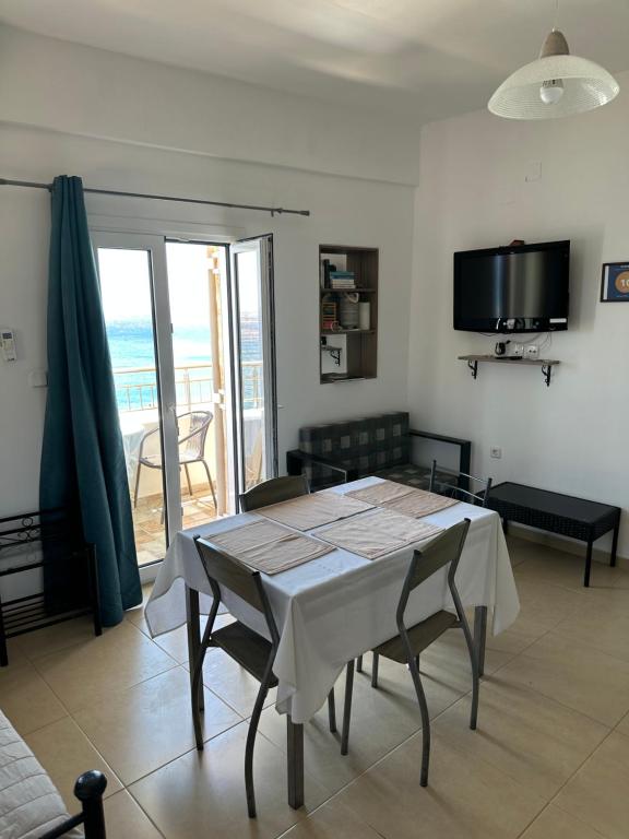 a dining room with a table and a view of the ocean at House With View in Paránimfoi