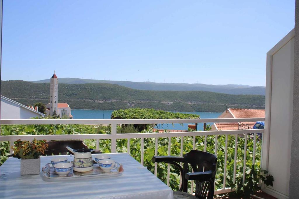 a table on a balcony with a view of the water at Apartments Kata in Neum