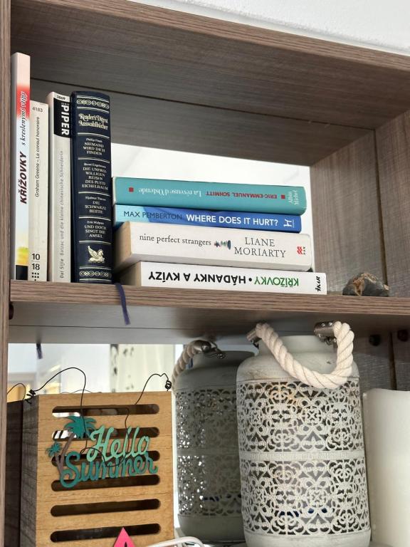 a book shelf with books and vases on it at House With View in Paránimfoi
