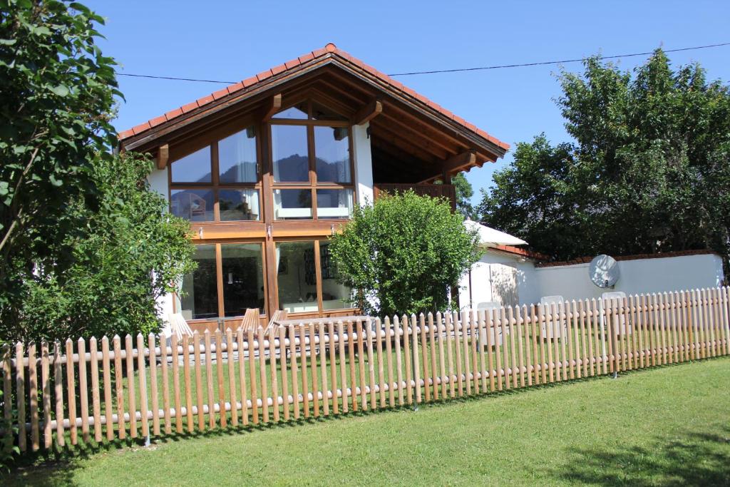 une maison avec une clôture en bois devant elle dans l'établissement Ferienhaus Sissi, à Schwangau