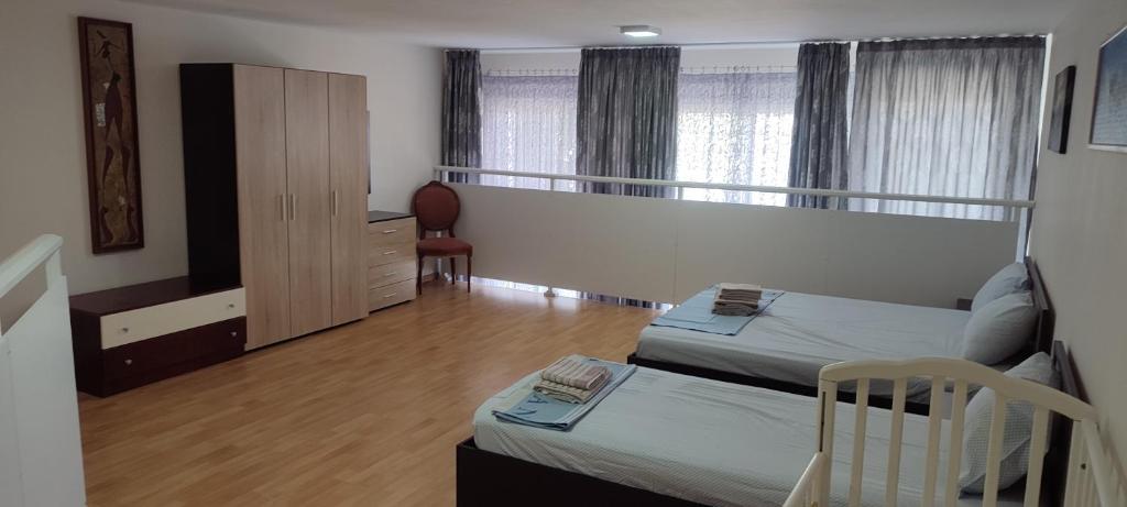 a bedroom with two beds and a dresser in it at Marianna's apartment 2 in Nea Moudania
