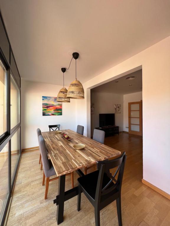 uma sala de jantar com uma mesa de madeira e cadeiras em CASA NEUS, casa junto a Barcelona em Sant Feliu de Llobregat