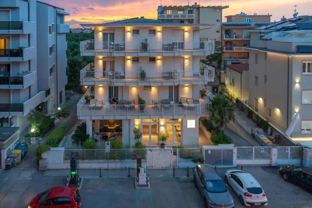 un edificio de apartamentos en una ciudad al atardecer en Hotel Riva e Mare en Rímini