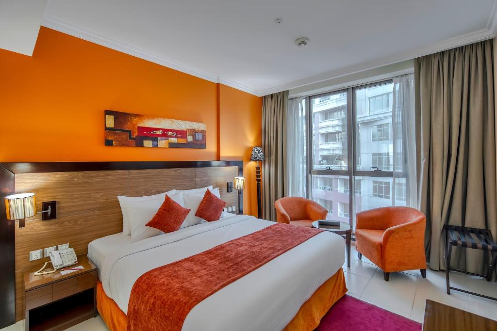 ein Hotelzimmer mit einem großen Bett und einem Fenster in der Unterkunft Icon Delux Hotel Apartments Al Barsha - Formerly Abidos in Dubai