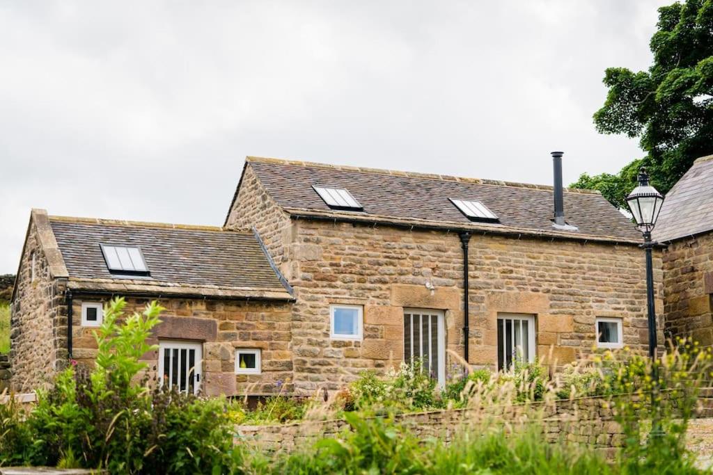 an old stone house with solar panels on it at Hilltop Farm - Middle Barn luxury accommodation in Tansley