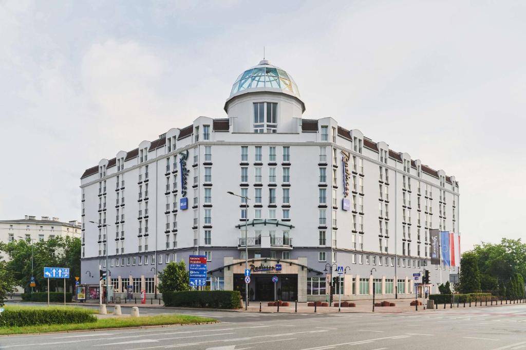 ein großes weißes Gebäude mit einer Kuppel darüber in der Unterkunft Radisson Blu Sobieski in Warschau