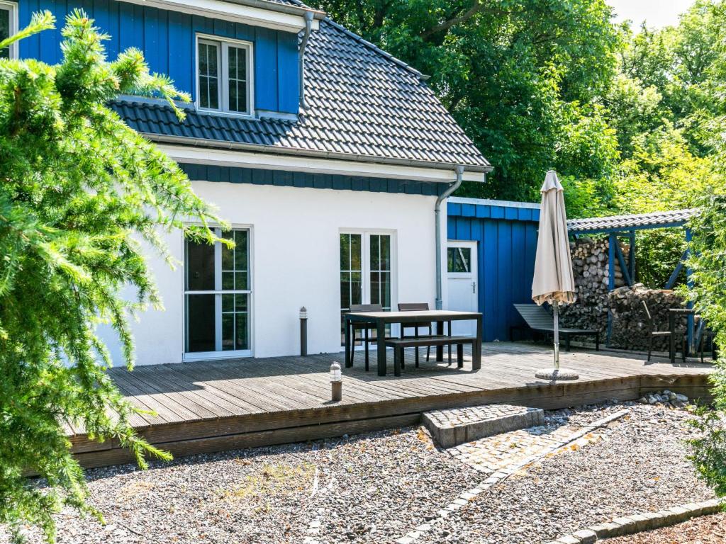 a patio with a table and an umbrella in front of a house at Holiday Home Boddenrauschen by Interhome in Ummanz