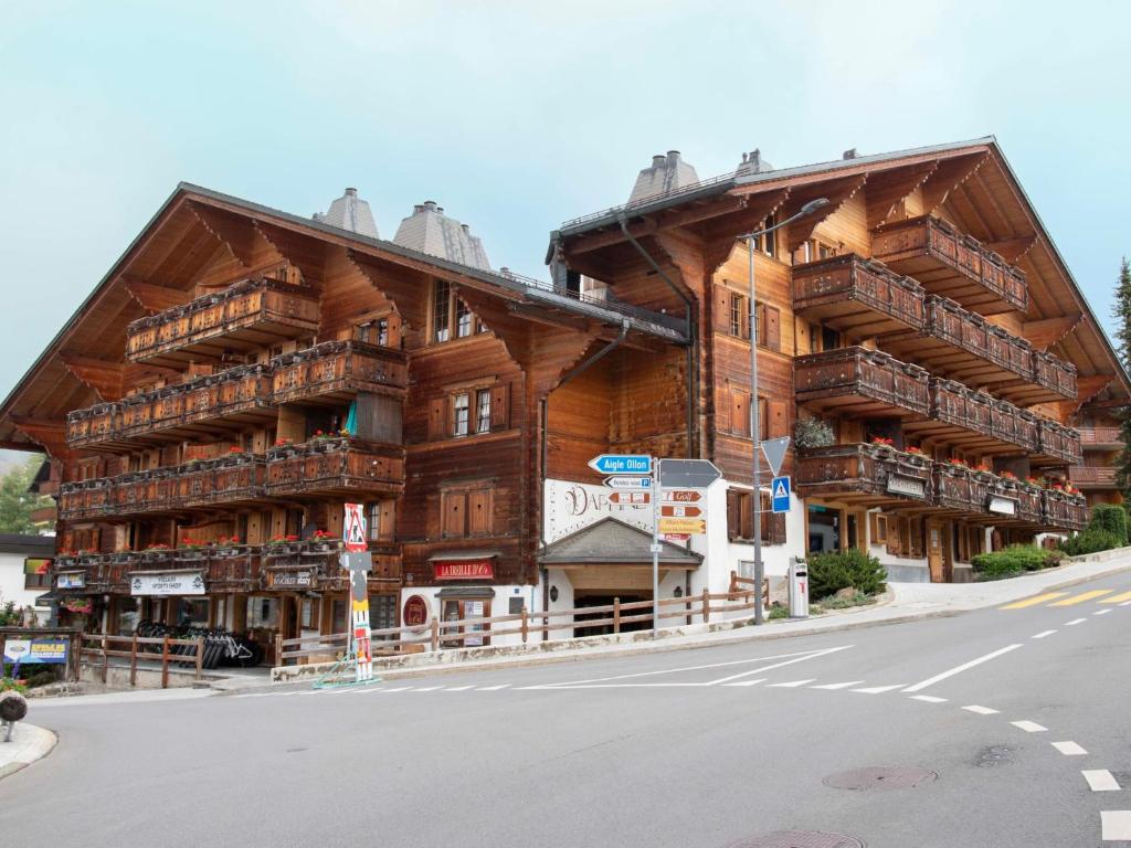 a large wooden building with balconies on a street at Apartment Daphné A 32 by Interhome in Villars-sur-Ollon
