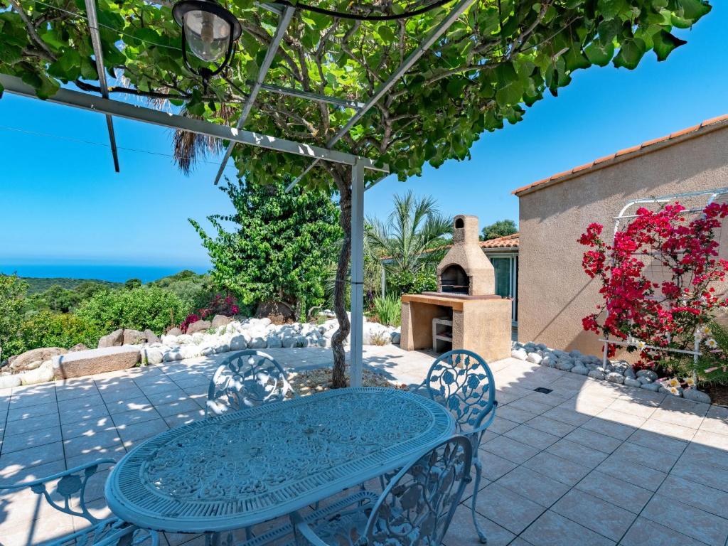 - une table bleue et des chaises sur une terrasse donnant sur l'océan dans l'établissement Holiday Home Campestra by Interhome, à Coti-Chiavari