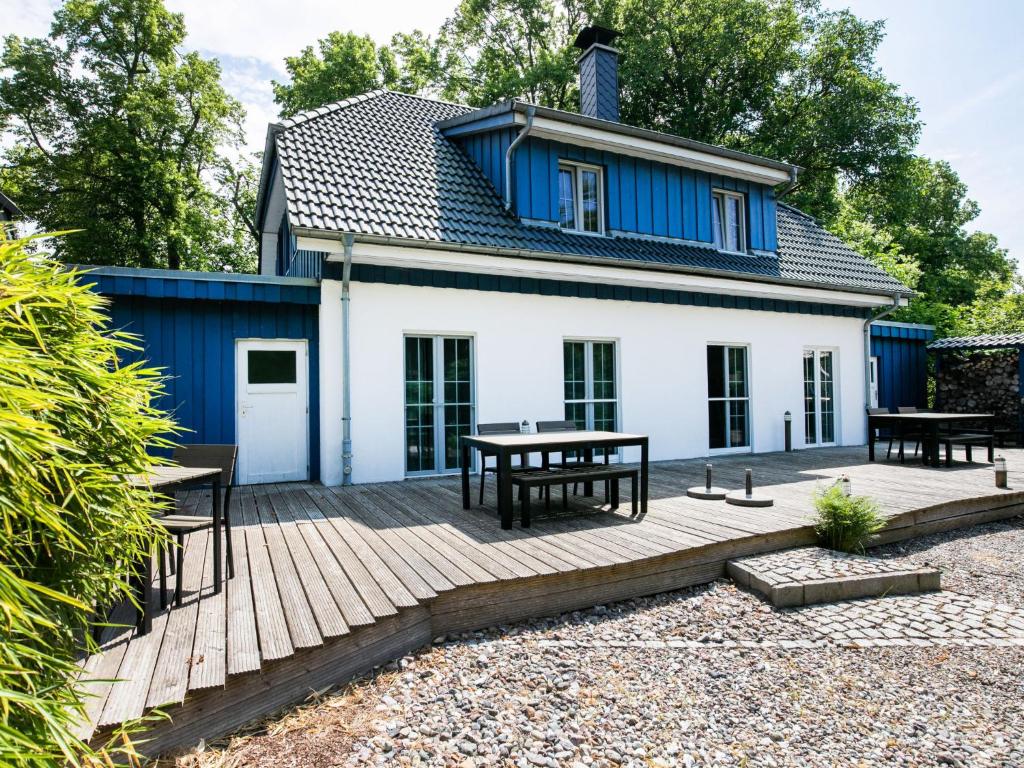 a house with a wooden deck in front of it at Holiday Home Boddenruhe by Interhome in Ummanz