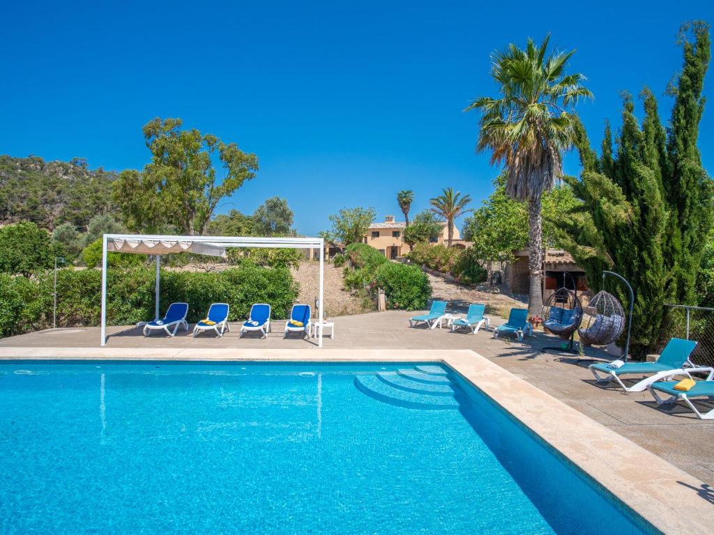 una piscina con tumbonas azules y una palmera en Holiday Home Can Amagat by Interhome, en Felanitx