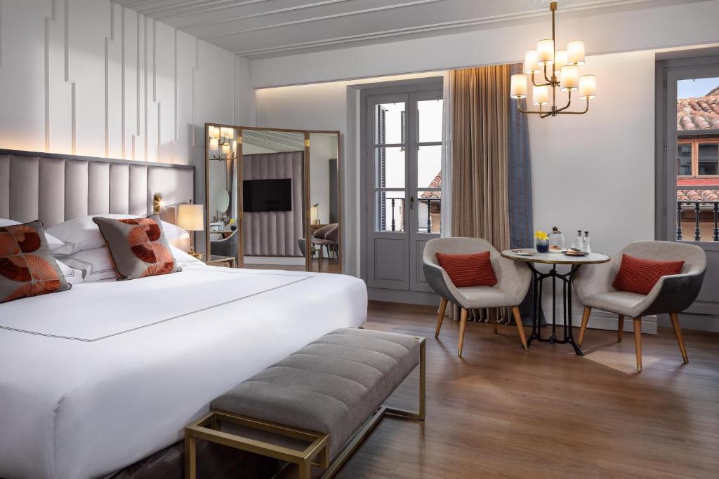 マドリードにあるGran Hotel Inglés - The Leading Hotels of the Worldのベッドルーム1室(大型ベッド1台、テーブル、椅子付)