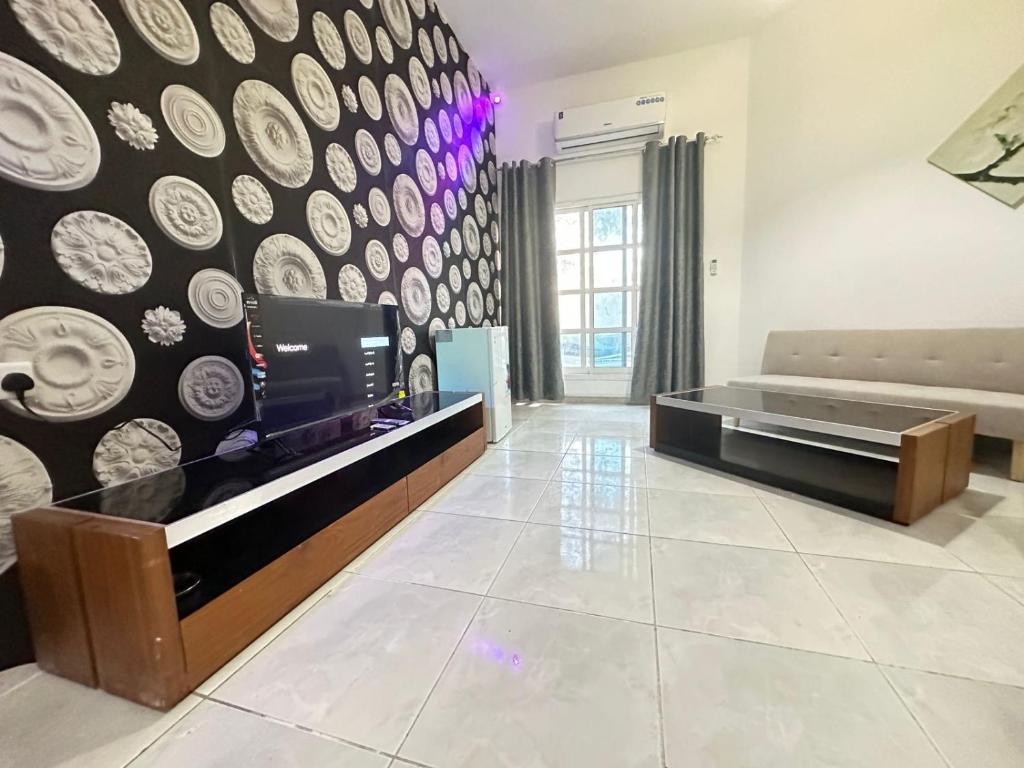 - un salon avec une télévision et un mur avec des assiettes dans l'établissement Relaxing Private Rooms in Compound Housing near Burj Alarab Villa 124, à Dubaï