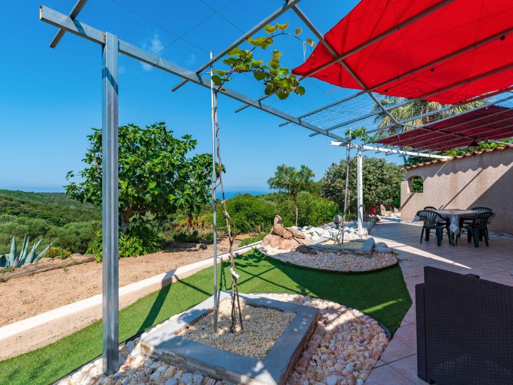 a patio with a red umbrella and a table at Holiday Home Campestra by Interhome in Coti-Chiavari