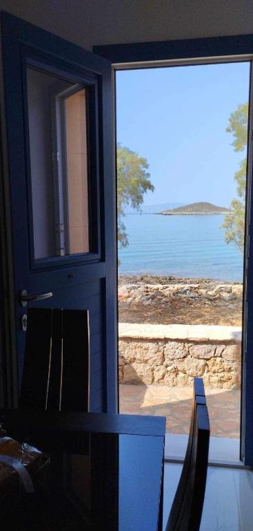 a door to a room with a view of the water at Diakofti house by the sea - Kythoikies hoilday houses in Kythira