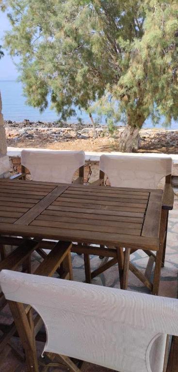 a wooden picnic table and chairs on a beach at Diakofti house by the sea - Kythoikies hoilday houses in Kythira
