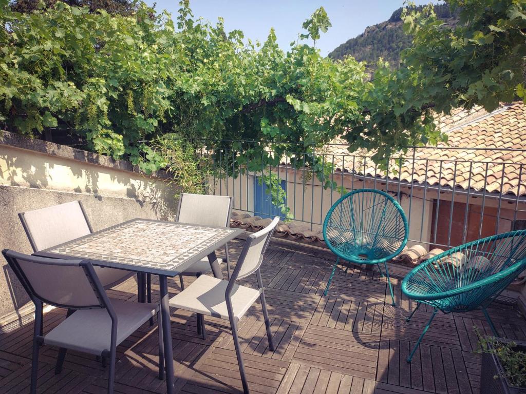 d'une terrasse avec une table et des chaises. dans l'établissement Maison de village avec terrasse, à Luc-en-Diois