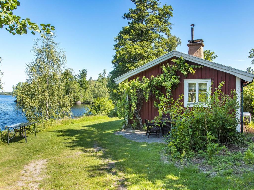 a small red house on the shore of a lake at Holiday Home Lidelund by Interhome in Tingsryd