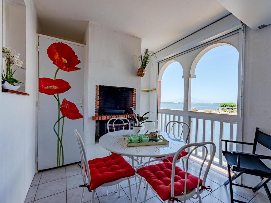 a dining room with a table and chairs and a view of the ocean at Apartment Pointe Vermeille-5 by Interhome in Le Barcarès