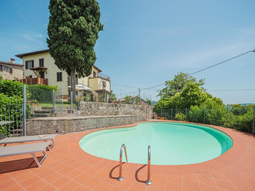 a swimming pool with a bench and a tree at Holiday Home Sara by Interhome in Gello