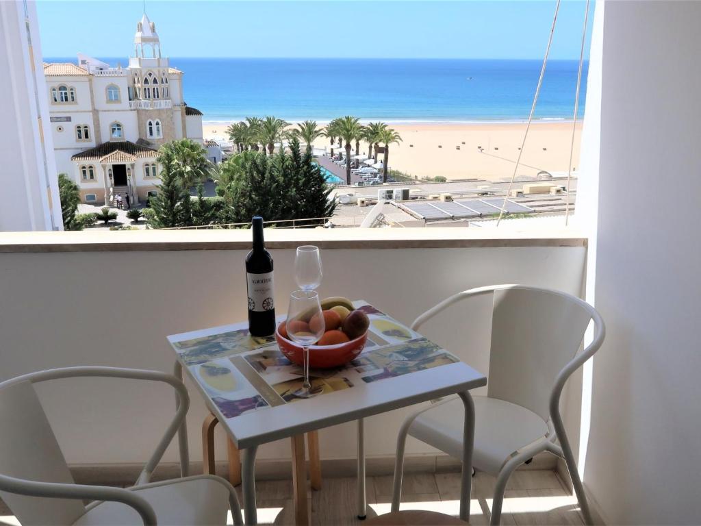 a table with a bottle of wine and a bowl of fruit at Apartment Casa Avó Lucy by Interhome in Portimão