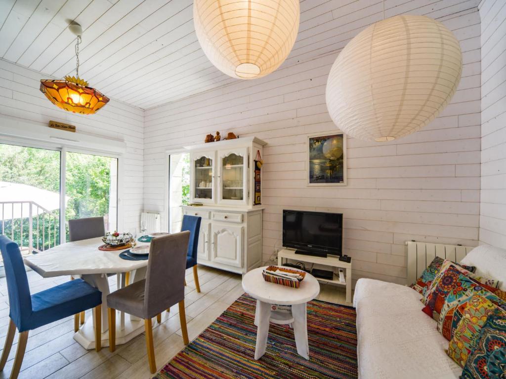 un salon avec une table et une télévision dans l'établissement Holiday Home La petite maison blanche by Interhome, à Chissay-en-Touraine