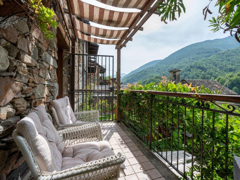 a balcony with two chairs and a view of mountains at Chalet Il Gianlupo by Interhome in Bognanco