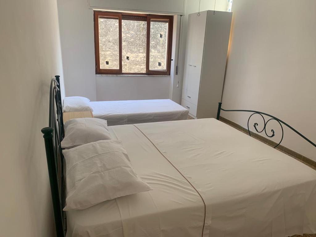 two beds in a small room with a window at B&B Casa Chicchina in Ischitella