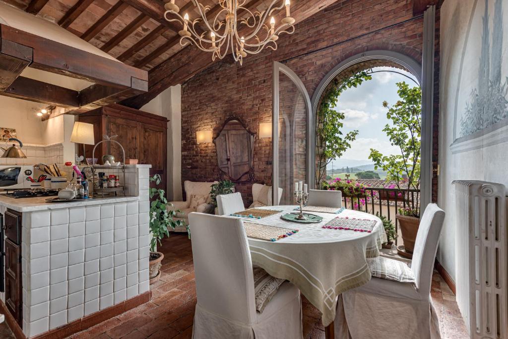 uma cozinha e sala de jantar com mesa e cadeiras em Pent House Duplex em San Donato in Poggio