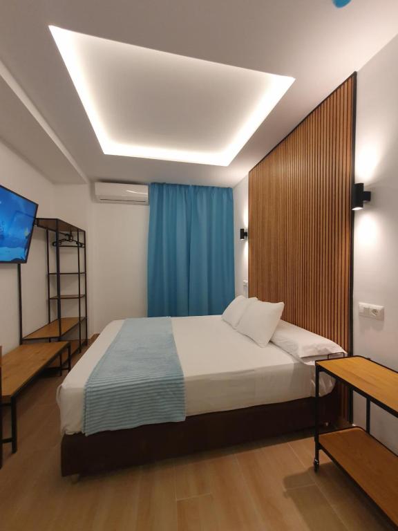 1 dormitorio con 1 cama y TV en El Nogal Home, en Málaga