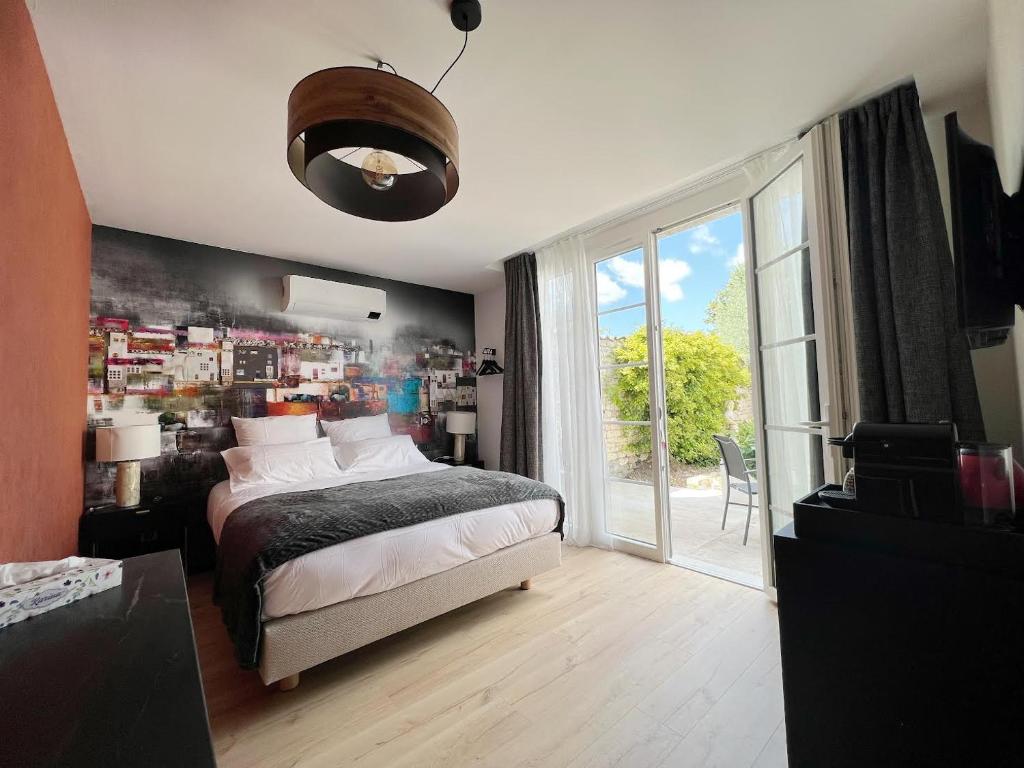 um quarto com uma cama e uma grande janela em Le 240b #1 em Saint-Mard