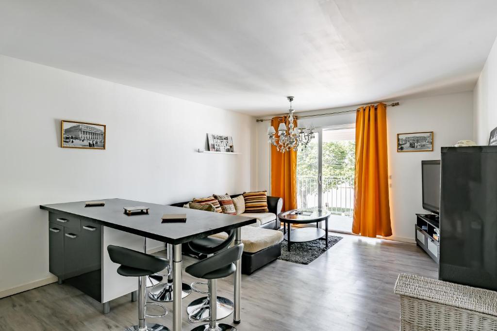 a kitchen and living room with a table and chairs at Le Long du Fleuve - Appt avec balcon vue fleuve in Saint-André-de-Cubzac