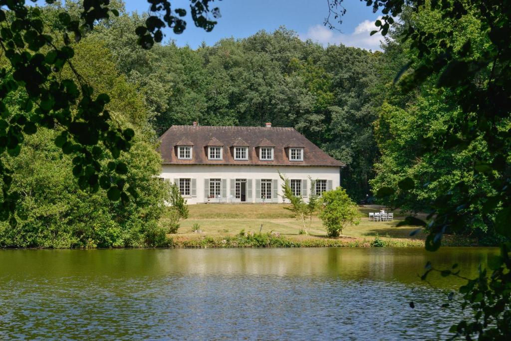La Genêtière - Grande maison avec étang en Sologne في Méry-ès-Bois: منزل كبير على جانب البحيرة