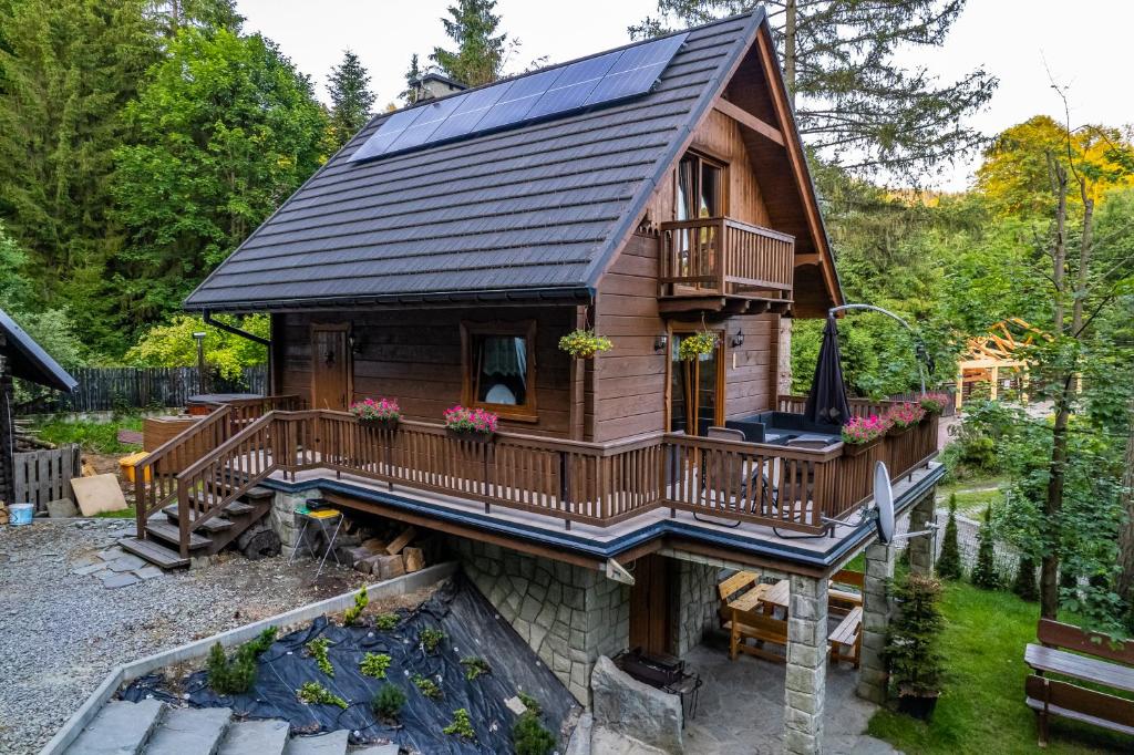 een tiny house met een zonnedak en een tuin bij Domki Brenna Leśnica chatka ze spa in Brenna