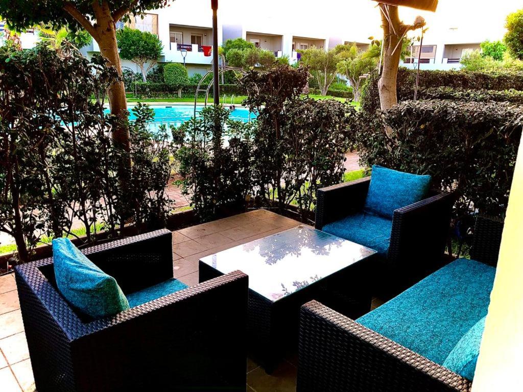 un patio con 2 sillas y una mesa con almohadas azules en Residence El jazzera beach en El Jadida
