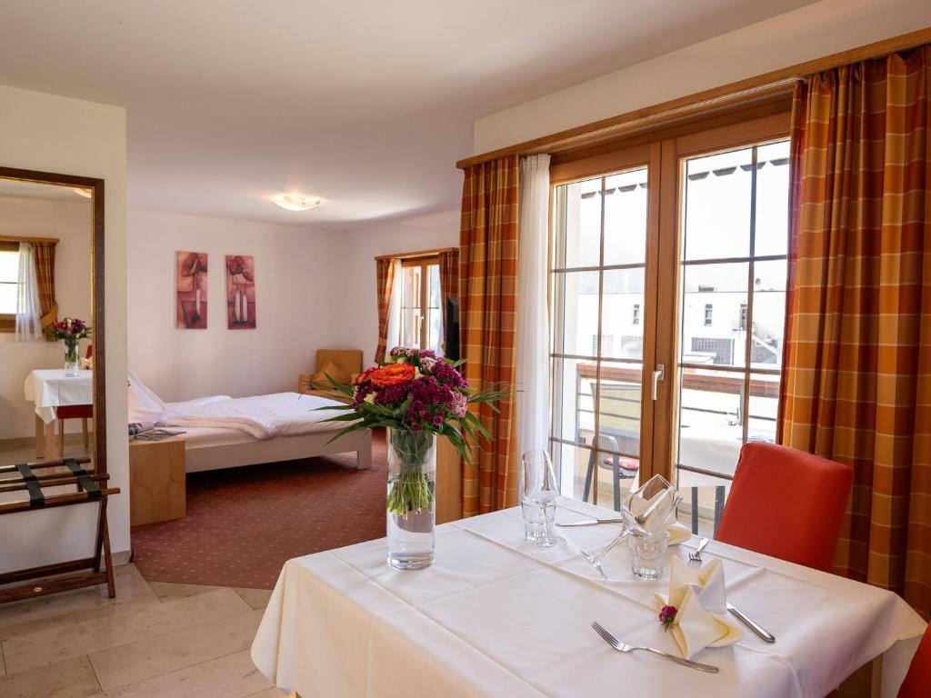 ein Zimmer mit einem Tisch mit einer Blumenvase darauf in der Unterkunft Apartment Allegra Sur 201 by Interhome in Zuoz