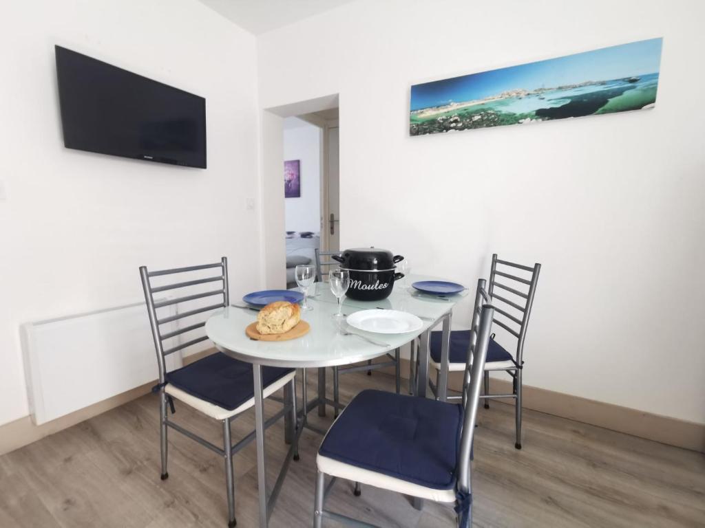a dining room with a white table and chairs at Apartment La Licorne by Interhome in Saint Malo