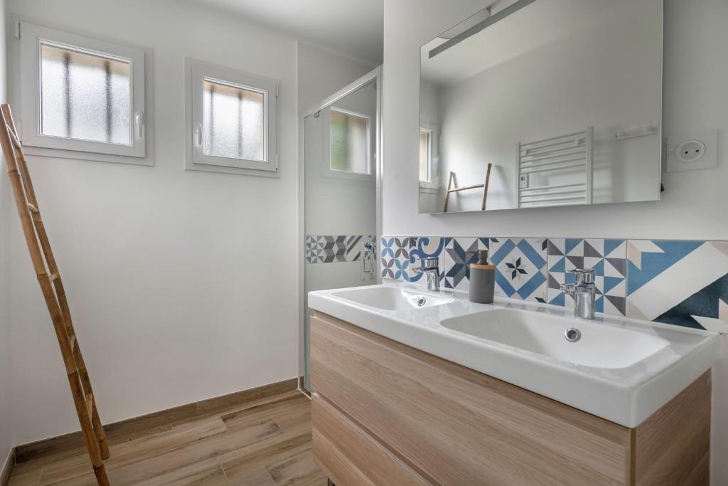 a bathroom with a white sink and a mirror at Detente au calme et pres de la plage in Saint-Gildas-de-Rhuys