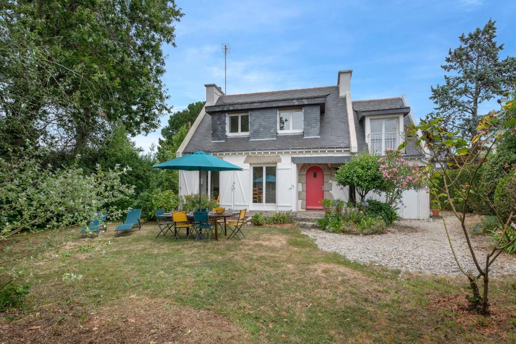 a house with a red door and a table and chairs at Detente au calme et pres de la plage in Saint-Gildas-de-Rhuys
