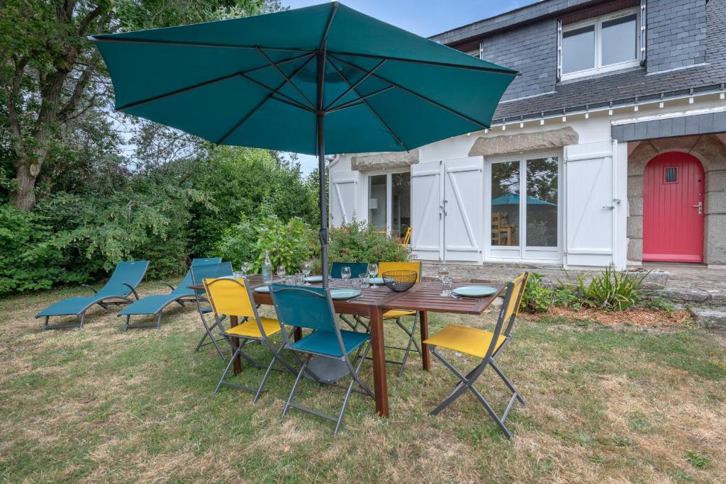 a table and chairs with an umbrella in the yard at Detente au calme et pres de la plage in Saint-Gildas-de-Rhuys