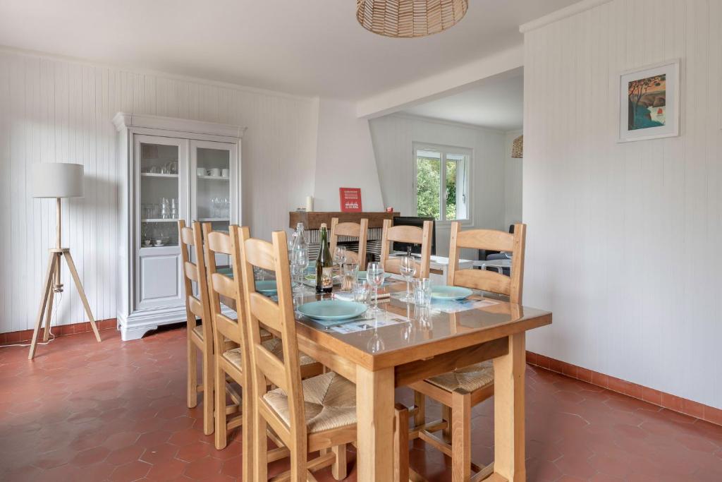 a dining room with a wooden table and chairs at Detente au calme et pres de la plage in Saint-Gildas-de-Rhuys