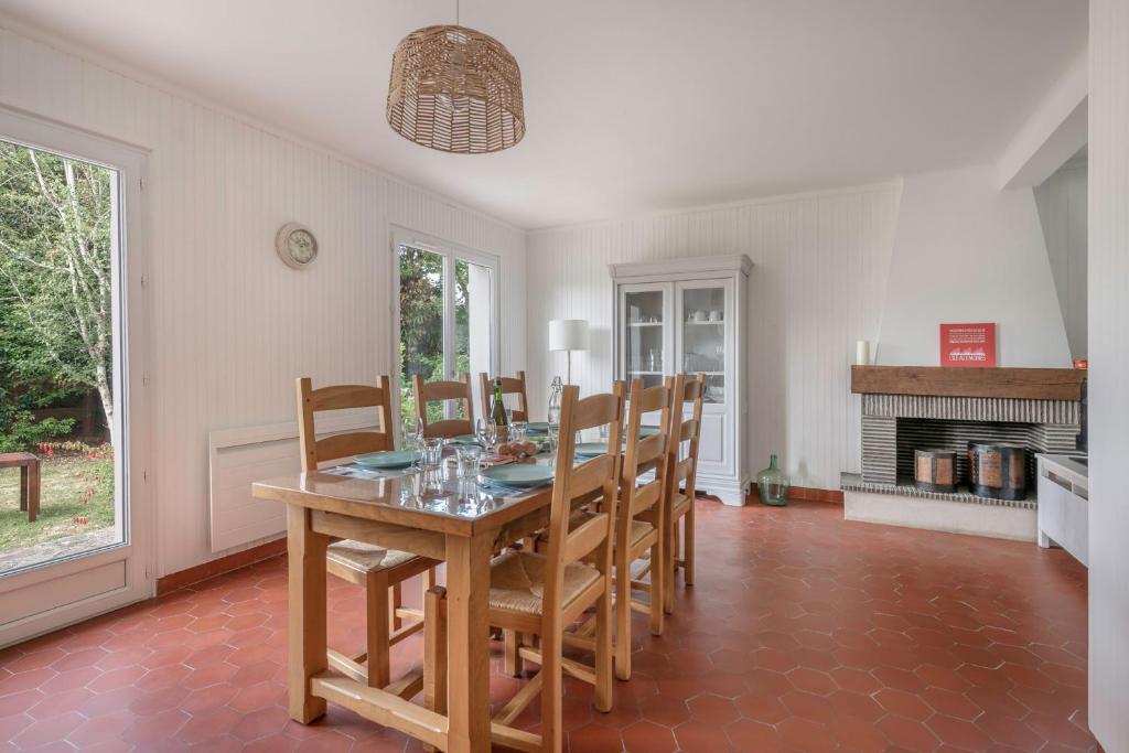 a dining room with a table and chairs and a fireplace at Detente au calme et pres de la plage in Saint-Gildas-de-Rhuys