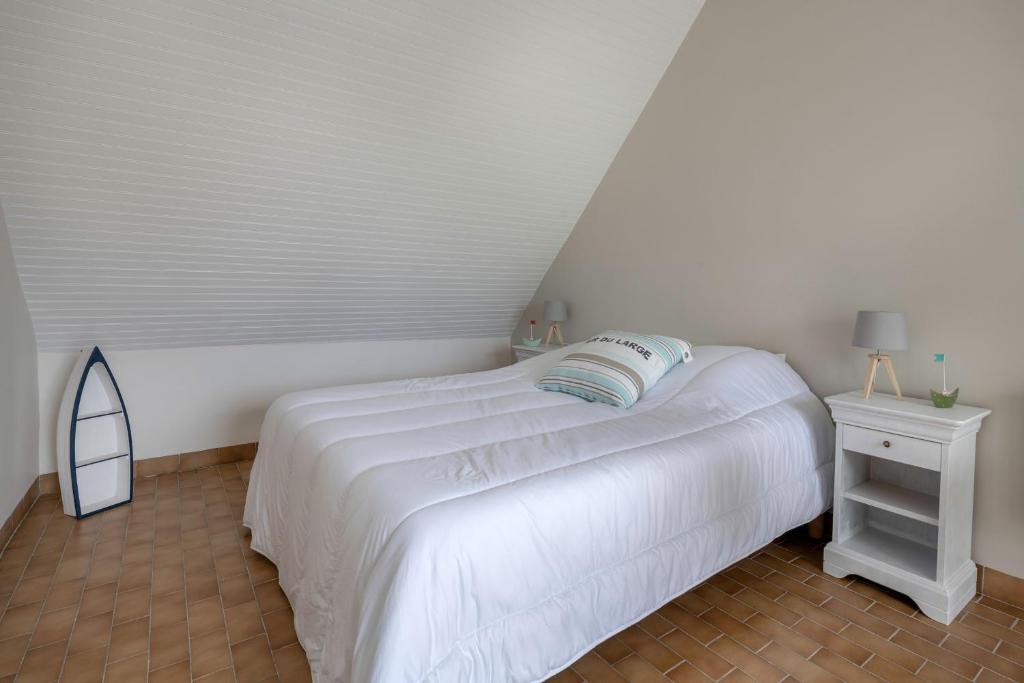 a white bedroom with a white bed and a mirror at Detente au calme et pres de la plage in Saint-Gildas-de-Rhuys