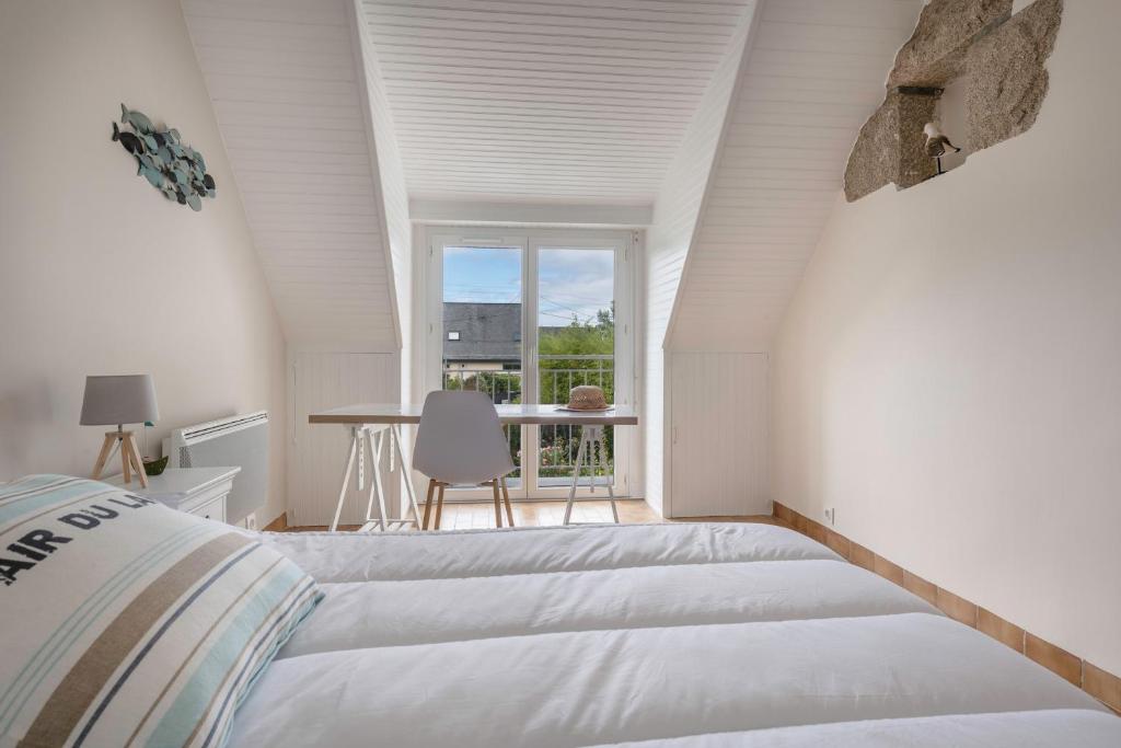 a white bedroom with a bed and a window at Detente au calme et pres de la plage in Saint-Gildas-de-Rhuys