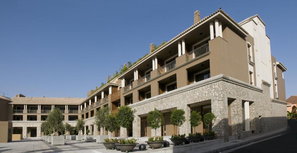 a large building with potted plants in front of it at Hotel Playa Calera in Valle Gran Rey