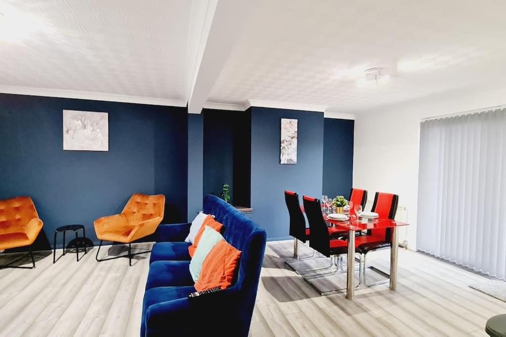 a living room with blue walls and a blue couch and a table at Saint Johns 3-bedroom House-Greater London in Dartford