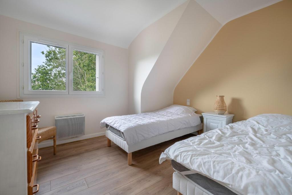 a bedroom with two beds and a window at Detente au calme et pres de la plage in Saint-Gildas-de-Rhuys
