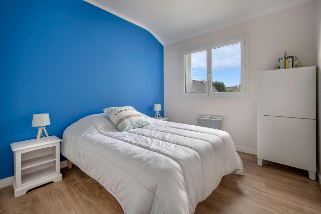 a blue bedroom with a bed and a white refrigerator at Detente au calme et pres de la plage in Saint-Gildas-de-Rhuys